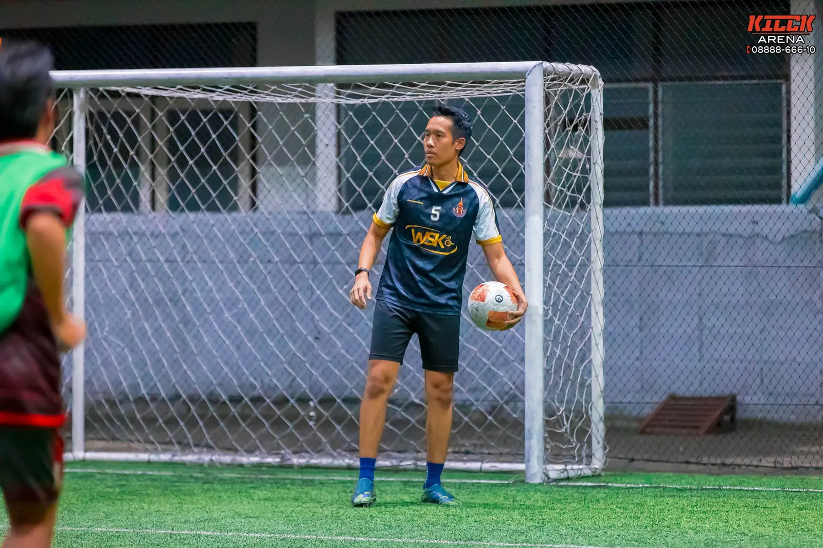 A goalkeeper holds the ball ready to throw