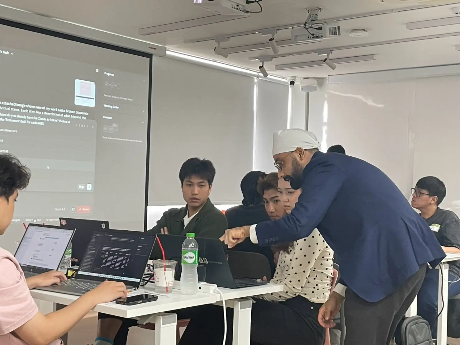 A trainer helps a colleague one to one