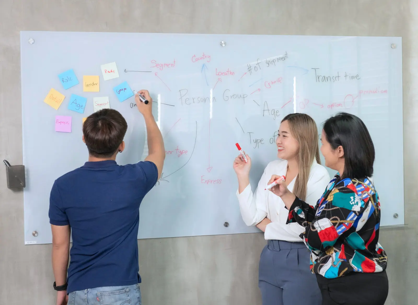Two colleagues sketching ideas on a whiteboard